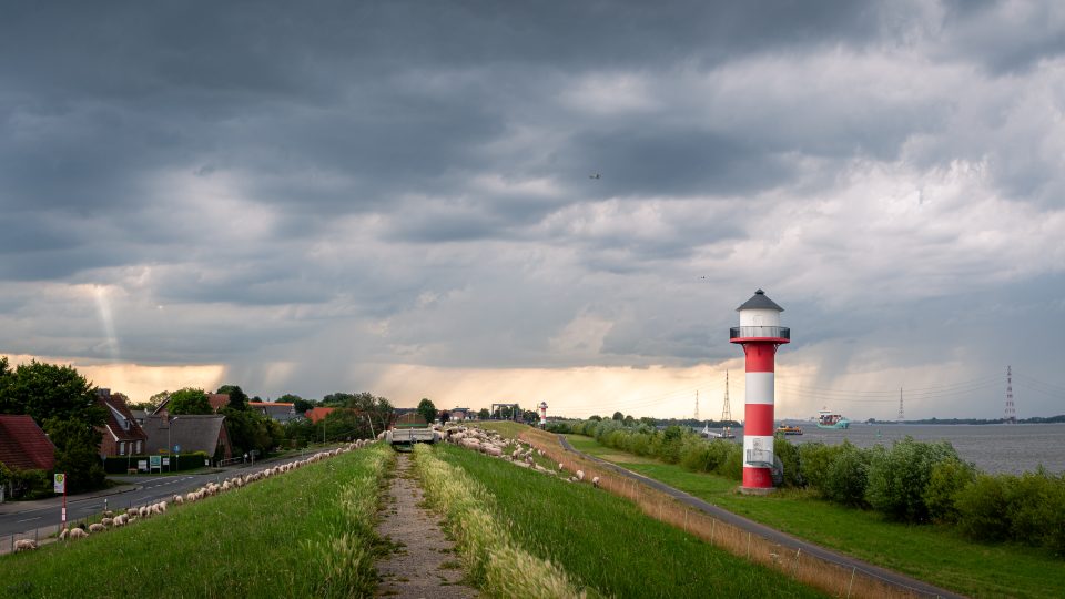 Gewitterwolken überqueren die Elbe im Alten Land von Nord nach Süd während die Sonne ein letztes Loch findet um zum Boden zu scheinen